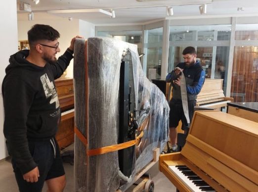 Nach dem Klavierkauf steht der Flügel zum Transportieren hochkant auf einem Rollwagen im Geschäft von Piano Fies in Oberkirch