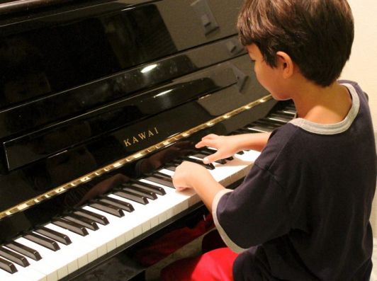 Ein Kind spielt Klavier. Klavier Mieten München, Umland und Oberland.