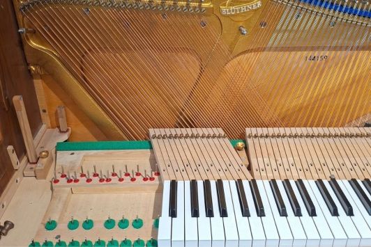 Tasten einrichten beim Blüthner Klavier. Die Tasten im Bass sind dafür teilweise ausgebaut.