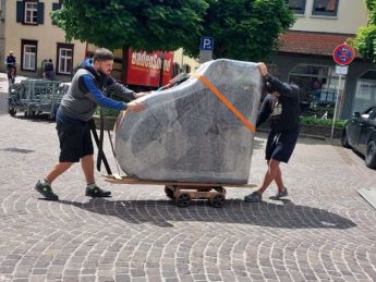 Der Flügel macht sich von Piano Fies aus mit den zwei Fachtransporteuren auf den Weg und wird auf dem Rollwagen in Oberkirch über Kopfsteinpflaster gerollt